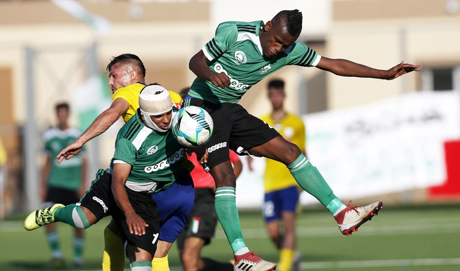 Players of Khadamat Rafah Club vie for the ball against Balata Sports Center during the first leg match of the Palestine Cup final in Rafah in the southern Gaza Strip on June 30, 2019. (AFP file photo)