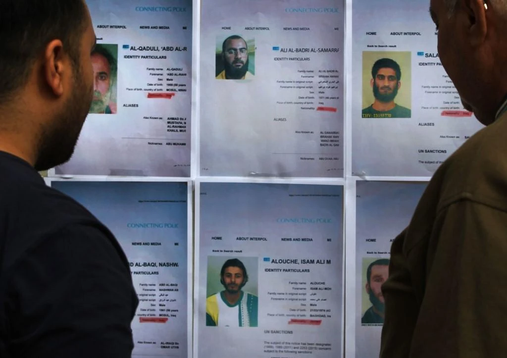 Residents look at printed profiles of Daesh group members released by Iraqi authorities on February 6, 2018. As much as 20,000 prisoners are being held in Iraq for alleged Daesh links. (AFP)