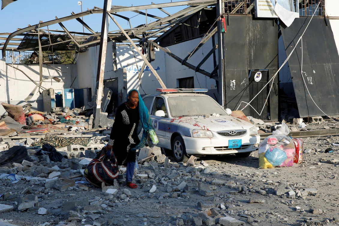 A migrant picks up her belongings from among rubble at a detention centre for mainly African migrants that was hit by an airstrike in the Tajoura suburb of the Libyan capital of Tripoli, Libya July 3, 2019. (Reuters)
