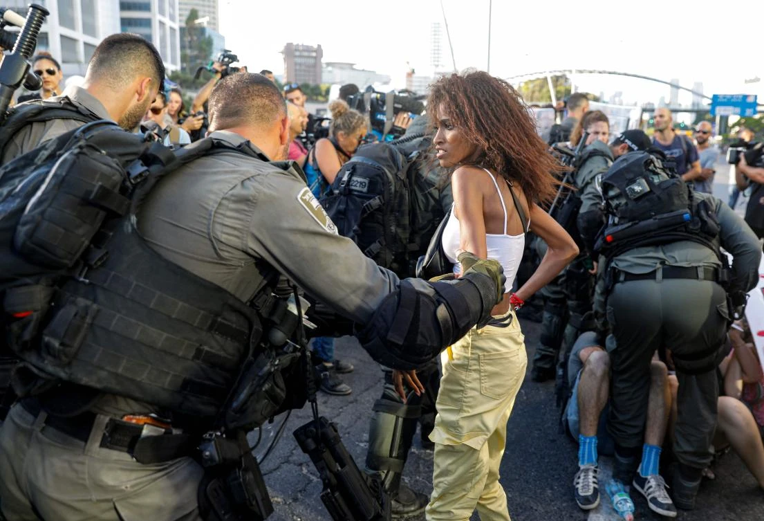 Members of the Israeli security forces detain a protester during a demonstration in Tel Aviv against police violence and the recent killing of a young man. (AFP)