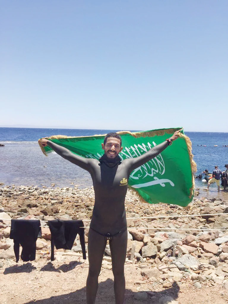 In this file photo, Bassam Bakheet raises the Saudi flag after winning in a free diving competition. (Supplied photo)