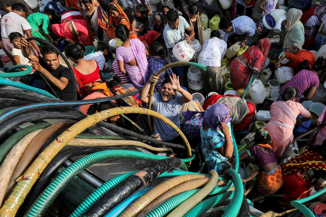 Residents fill their containers with drinking water from a municipal tanker in New Delhi. (Reuters)