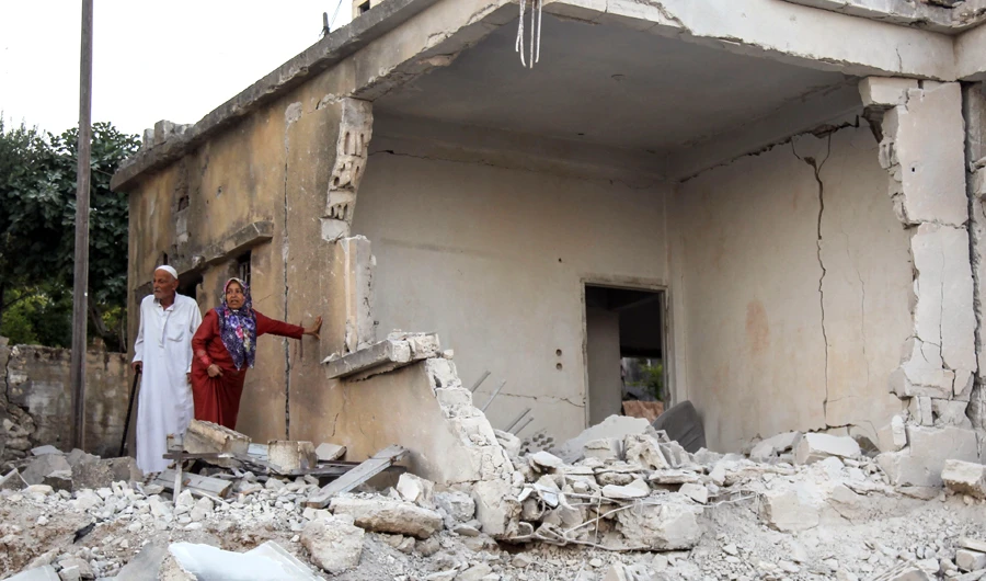 Syrians inspect the damage following reported regime airstrikes on the town of Muhambal, in the northern Idlib province on July 6, 2019. (AFP)