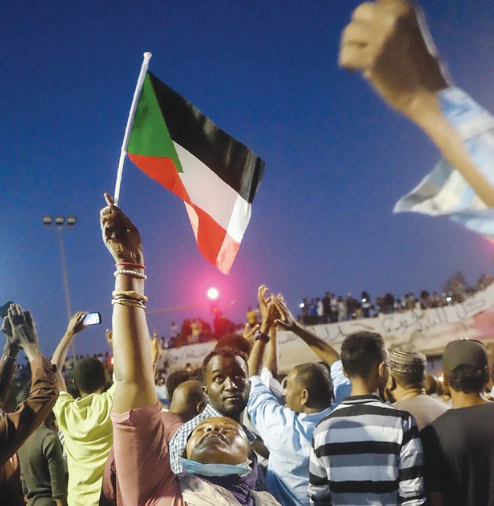 A Sudanese woman chants slogans and wave national flag in celebration, following a power-sharing agreement between ruling military council and the opposition in Khartoum on Friday. (Reuters)