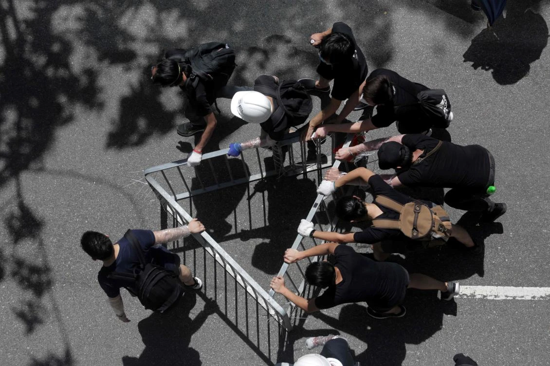 Protesters carry an improvised set of barricades as they attempt to enter the government headquarters in Hong Kong on July 1, 2019, on the 22nd anniversary of the city’s handover from Britain to China. (AFP/Vivek Prakash)