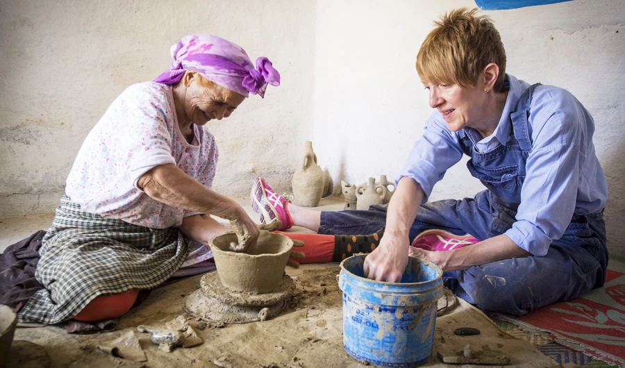 Moroccan potter Aicha Tabiz (L), also known as Mama Aicha, sits next to British apprentice Kim West, 33, during a pottery workshop near the village of Ourtzagh in the foothills of the Rif mountains on June 12, 2019. (AFP)