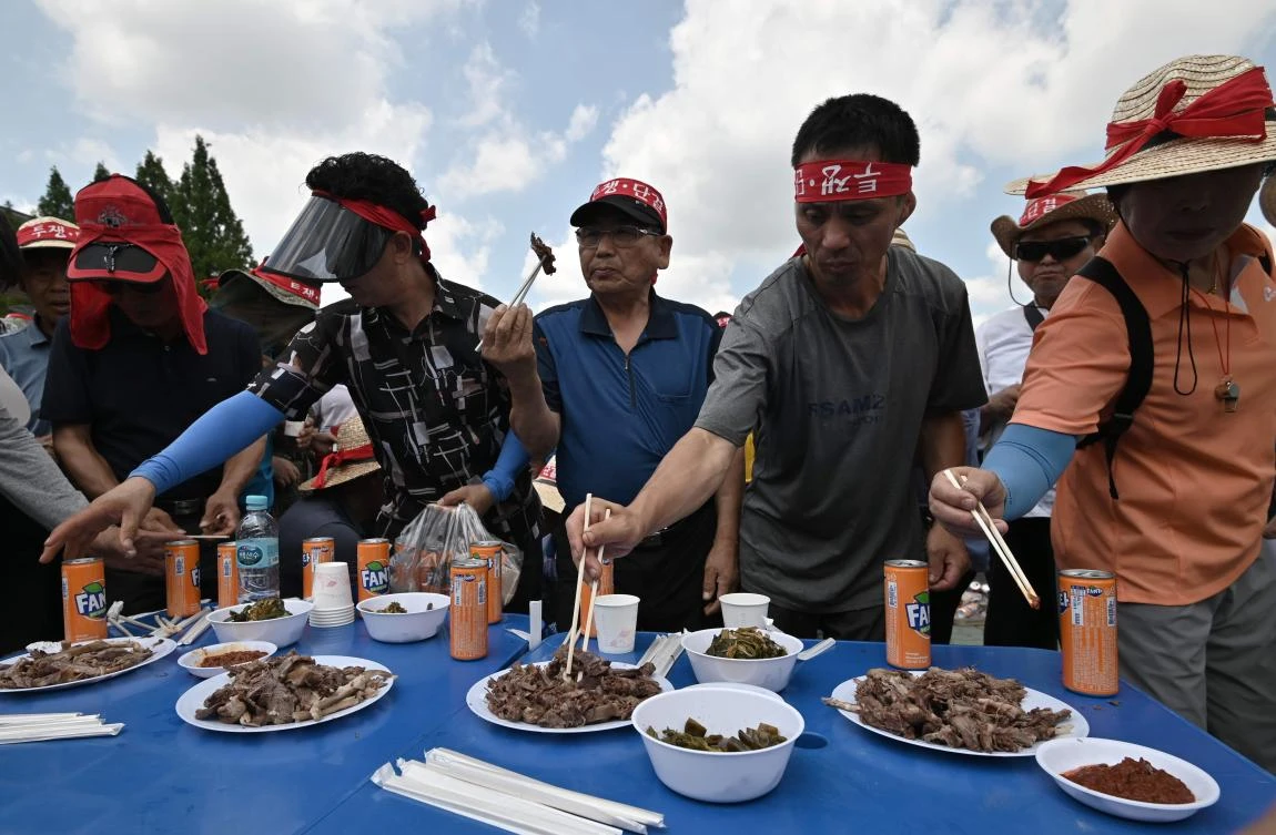 South Korean dog farmers eat dog meat during a counter-rally against animal rights activists demonstrating against the meat’s trade on Friday, July 12, 2019. (AFP)