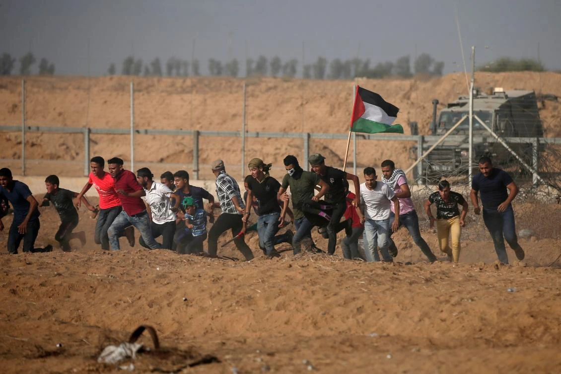Palestinian demonstrators run away from the fence during protests along the border with Israel, east of Khan Yunis, in the southern Gaza Strip on July 12, 2019. (AFP)