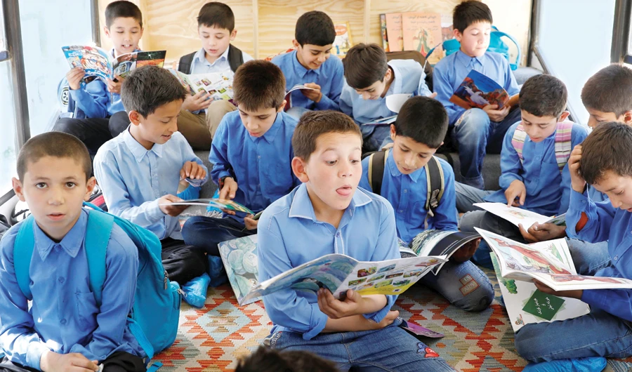 Afghan boys read books inside a mobile library bus in Kabul. (File/Reuters)