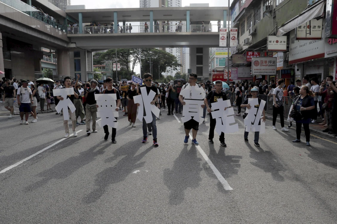 Protesters hold up words that read: ‘Against smuggling grey goods’ in Hong Kong on Saturday, July 13, 2019. (AP)