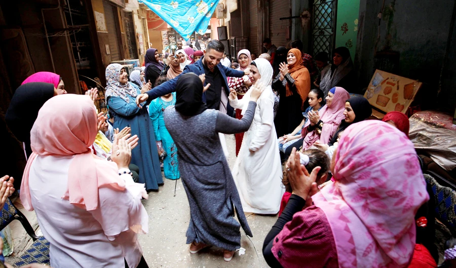 Nadia Mohammad Salem dances with her relatives outside her family home the day before her wedding, in Cairo, Egypt November 2, 2018. (REUTERS)