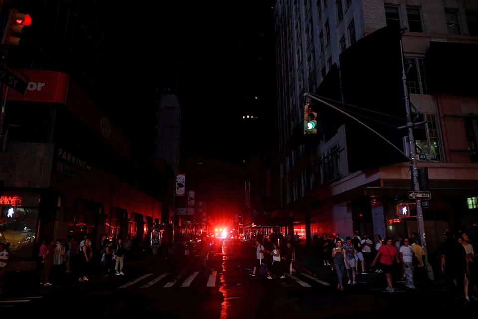 People walk down a street of Manhattan after a power outage hit the borough in New York City on July 13, 2019.(AFP / Johannes Eisele)