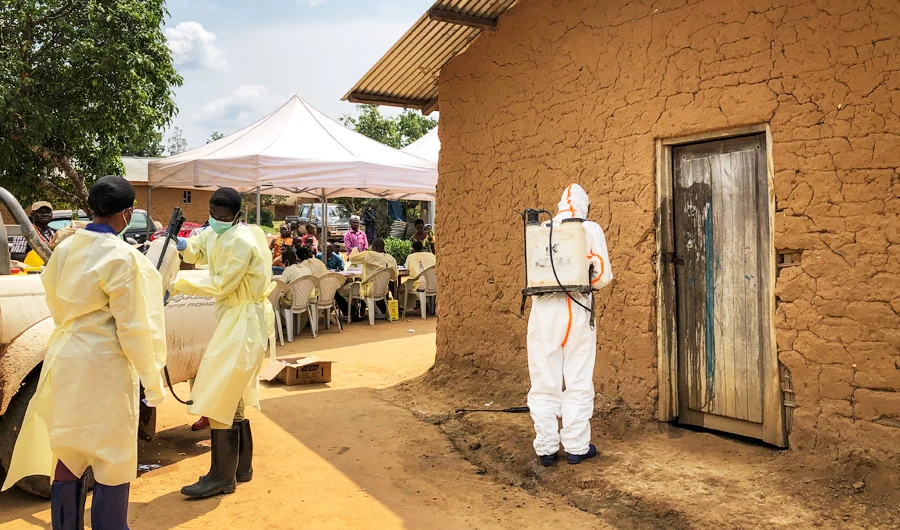 A worker from the World Health Organization (WHO) decontaminates the doorway of a house on a plot where two cases of Ebola were found, in the village of Mabalako, in eastern Congo Monday, June 17, 2019. (AP)