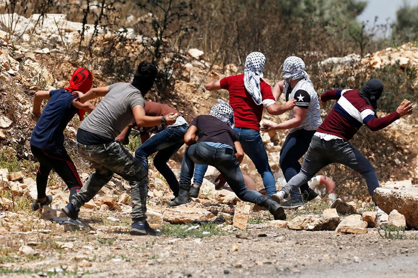 Palestinian protesters throw stones at Israeli security forces during clashes in the village of Kfar Qaddum in the Israeli-occupied West Bank on July 12, 2019 following a weekly demonstration against the expropriation of Palestinian land by Israel. (AFP / JAAFAR ASHTIYEH)