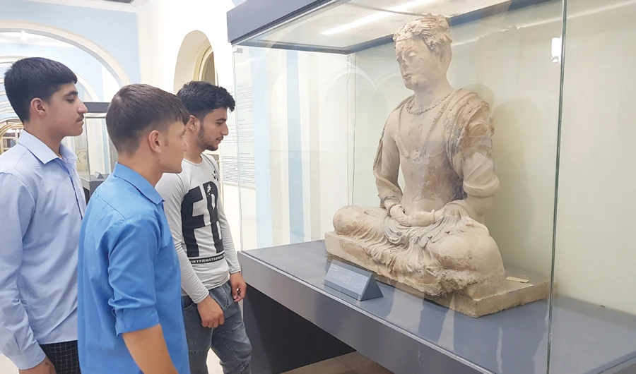 Visitors are visibly impressed by one of the ancient relics on display in Kabul Museum on Saturday. (AN photo by Sayed Salahuddin)