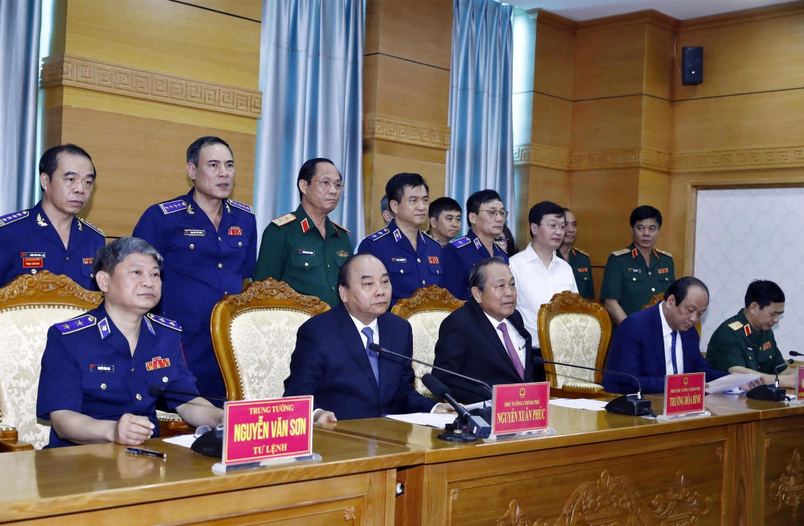 Vietnam’s Prime Minister Nguyen Xuan Phuc, second left, front, and Deputy Prime Minister Truong Hoa Binh, second right, front, speak with deployed Coast Guard Force sailors via video call on July 11, 2019. (VNA via Reuters)