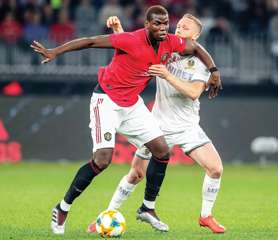 Manchester United’s Paul Pogba, left, fights for the ball with Leeds United’s Adam Forshaw during their pre-season friendly match. (AFP)