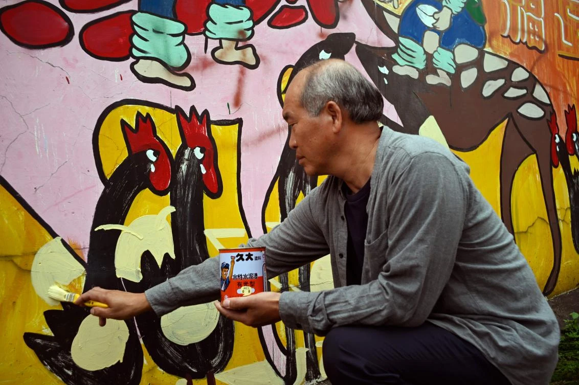 Hakka graffiti artist Wu Tsun-hsien, above, is coaxing the Instagram generation back by transforming local homes into a canvas of color. (AFP)