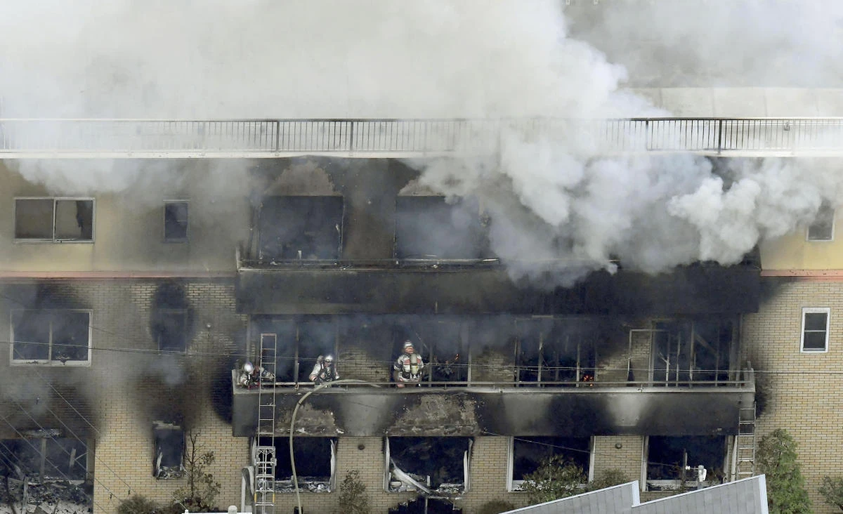 Firefighters work as smoke billows from a three-story building of Kyoto Animation in a fire in Kyoto on Thursday, July 18, 2019. (Kyodo News via AP)