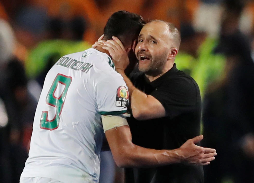Algeria’s Baghdad Bounedjah is embraced by coach Djamel Belmadi after he is substituted off, as his goal was enough to secure Algeria a second Africa Cup of Nations win. (Reuters)