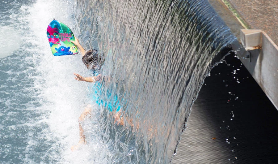 A child plays in a waterfall at Yards Park in Washington, DC, July 19, 2019, as an extreme heat wave hits the region. (AFP)