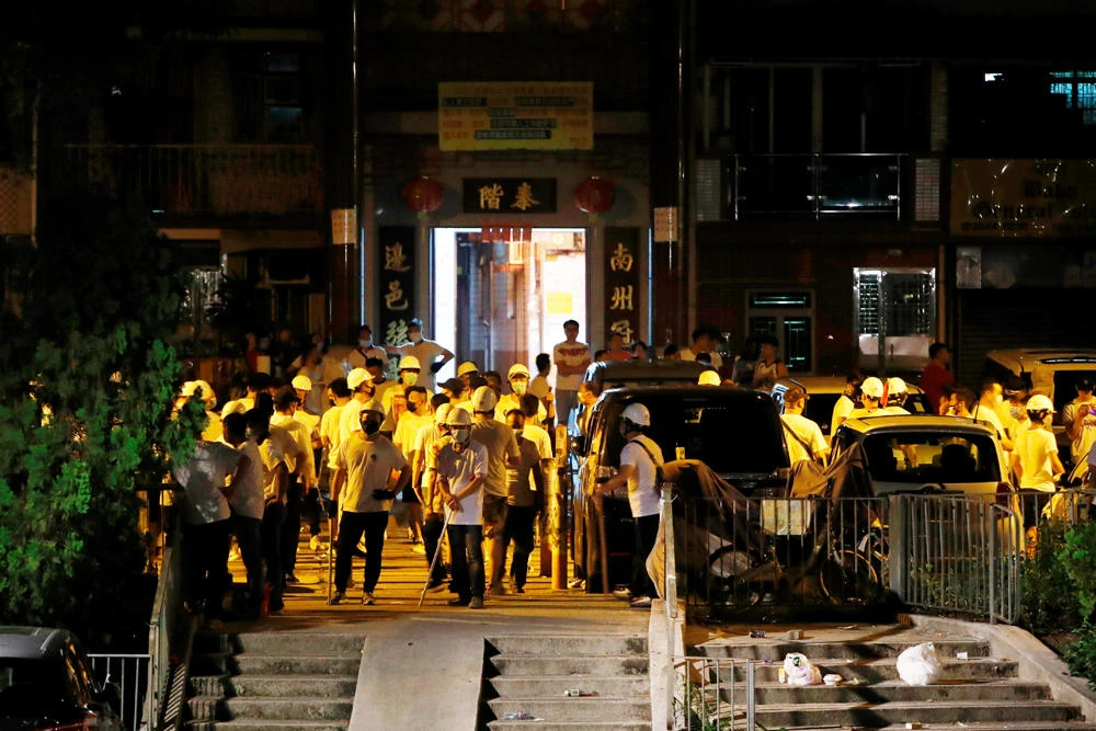 Men in white T-shirts with poles are seen in Yuen Long after attacking anti-extradition bill demonstrators at a train station in Hong Kong on July 21, 2019. (REUTERS/Tyrone Siu)