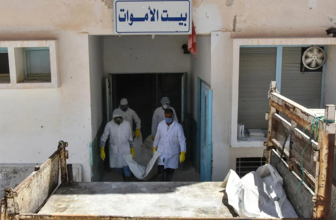 Forensic workers load into a truck the bodies of African migrants, who were recovered on the Tunisian coast and will be buried at a communal cemetery in El Ketif near the eastern coastal city of Zarzis, outside the Gabes hospital morgue on July 17, 2019. (AFP)