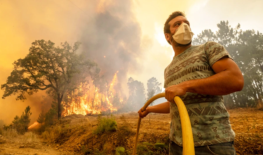 A villager tries to extinguish a wildfire at the village of Chaveira, near Macao, in central Portugal on Monday, July 22, 2019. (AP)
