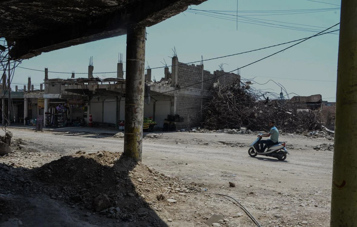 A men drives his scooter in front of damaged buildings in the old city of Mosul in northern Iraq , on July 22, 2019. (AFP)