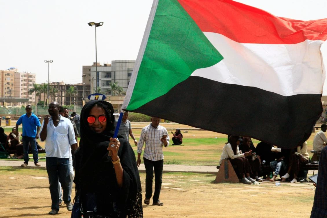 A Sudanese protester waves the national flag in the capital Khartoum's Green Square on July 18, 2019, during a rally to honour comrades killed in the months-long protest movement that has rocked the country. (AFP )