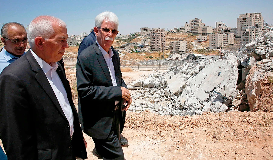 Members of the Fatah Movement visiting the site of demolished buildings in the West Bank, adjacent to the area of Sur Baher (L) in East Jerusalem. (AFP)