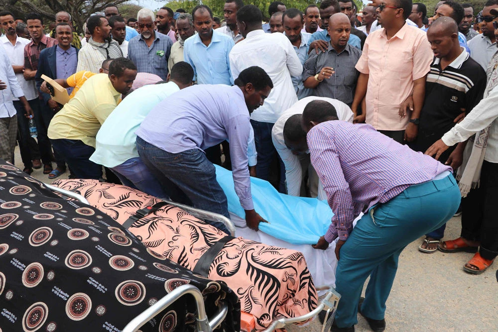 Relatives lay down on July 25, 2019 the dead body of one of Mogadishu district commissioners who was killed in a suicide bomb attack on July 24. (AFP / Abdirazak Hussein Farah)