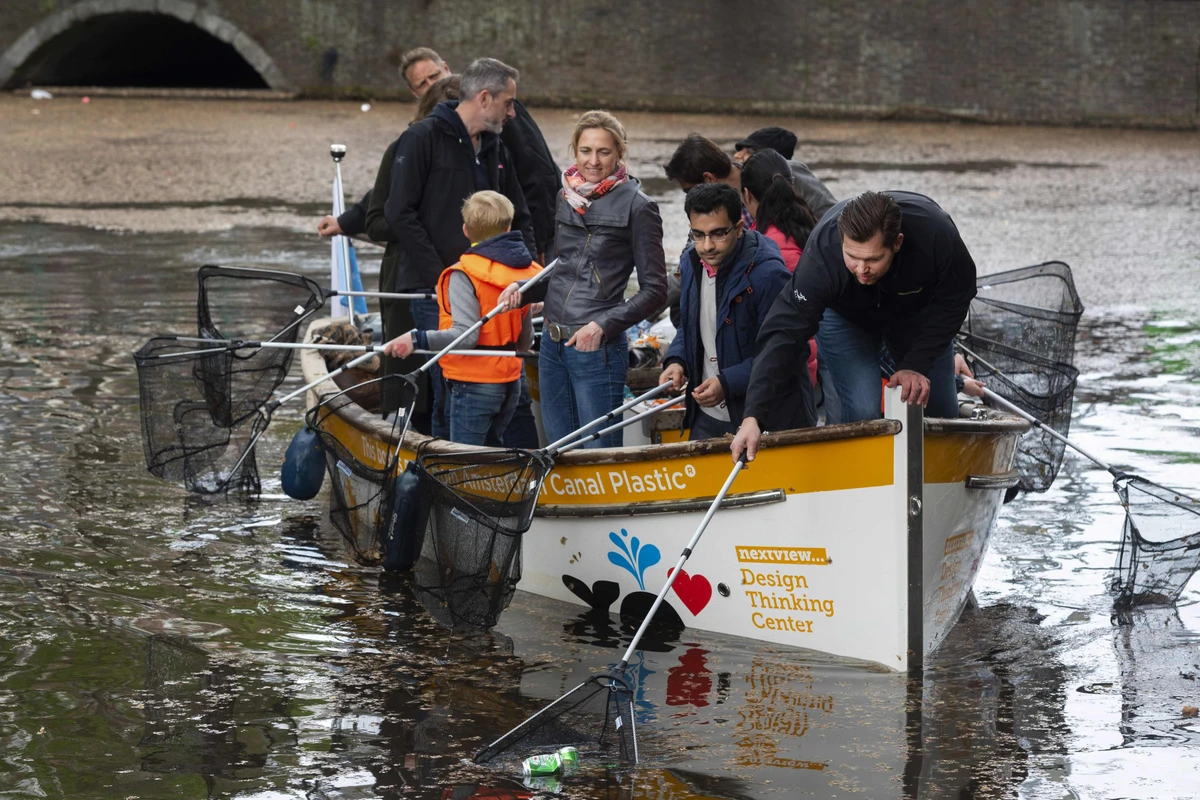 In this file photo, volunteers fish plastic out of a canal as they take part in the annual Kings Fishing to make the canals plastic-free again organised by the Plastic Whale Foundation in Amsterdam on April 28, 2019. (AFP)