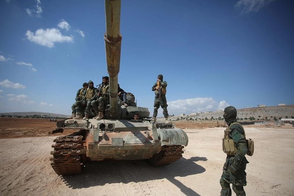 Fighters of Jaysh al-Izza, a formerly US-backed Syrian rebel group active in northern Hama province and parts of Idlib, take part in a military show during their graduation ceremony at a training camp near the Bab al-Hawa crossing between Idlib province and Turkey on July 18, 2019. (File/AFP)