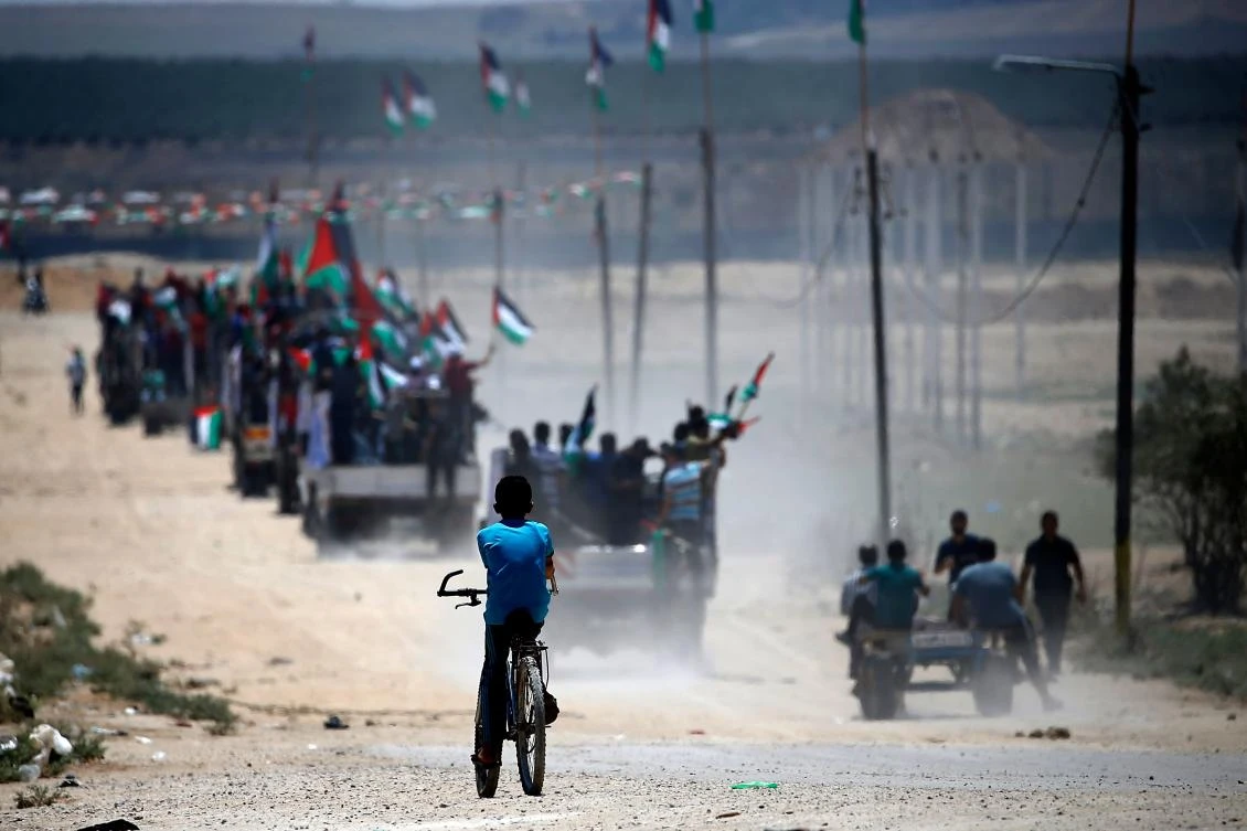 Palestinian demonstrators wave their national flag as they drive toward the border fence with Israel, east of Gaza City on July 22, 2019. (AFP/Mohammed Abed)
