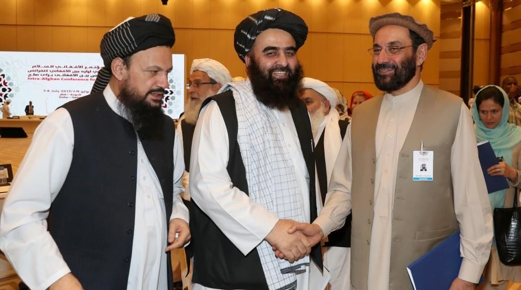 Amir Khan Mutaqi (C), the Taliban's former culture and information minister, shakes hands with Ghairat Baheer (R), member of the upper house of the Afghan assembly, as they stand alongside Abdul Latif Mansoor (L), the Taliban's former agriculture minister, during the Intra Afghan Dialogue talks in Doha. (File/AFP)