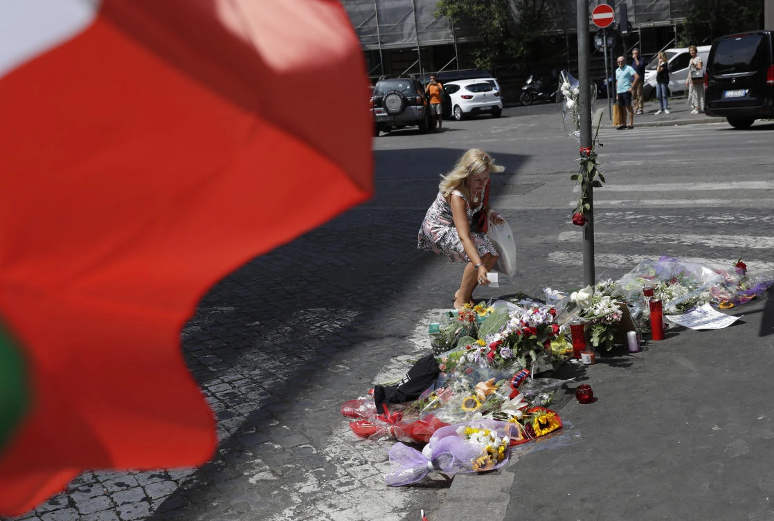 A woman leaves a note in memory on the spot where Mario Cerciello Rega was stabbed to death, in Rome, Saturday, July 27, 2019. (AP/Andrew Medichini)