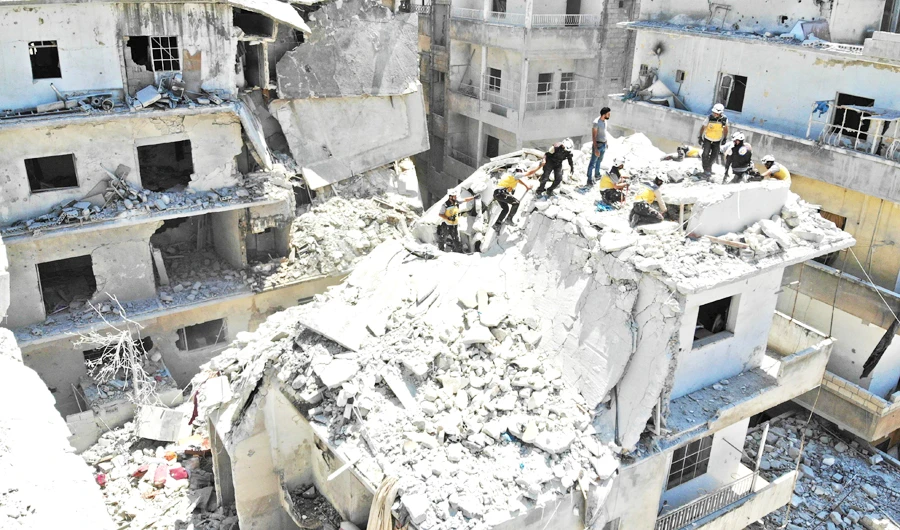 Members of the Syrian Civil Defense search for victims at the site of a reported airstrike on the town of Ariha, in the south of Syria's Idlib province, on Saturday. (AFP)