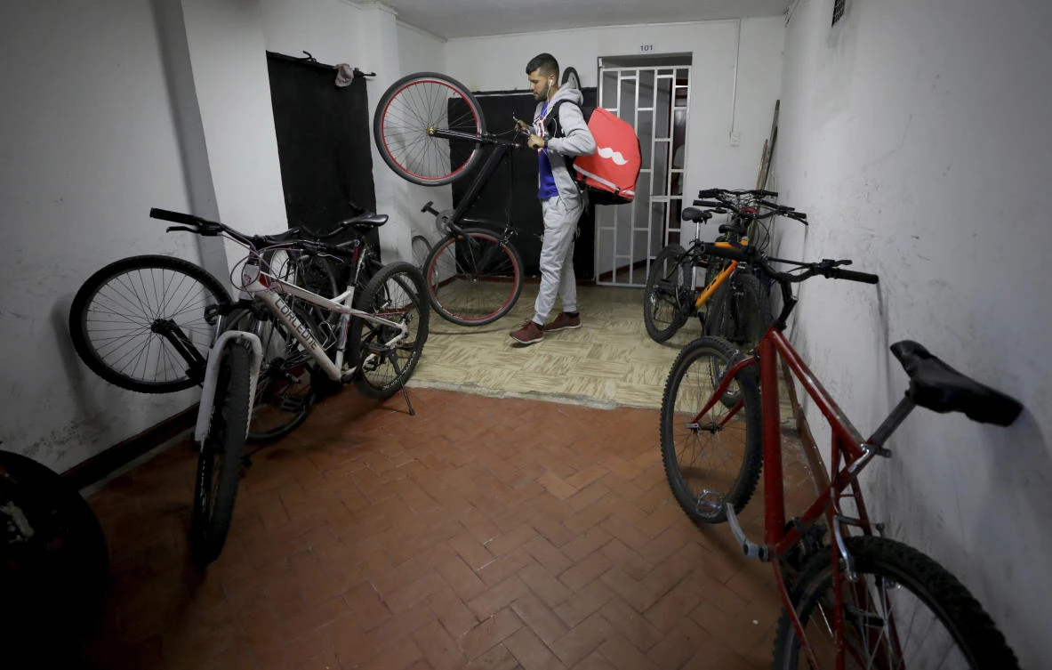 Venezuelan bicycle courier Samuel Romero who works with Rappi gets ready to start his work day in Bogota, Colombia, Wednesday, July 17, 2019. (AP/Fernando Vergara)