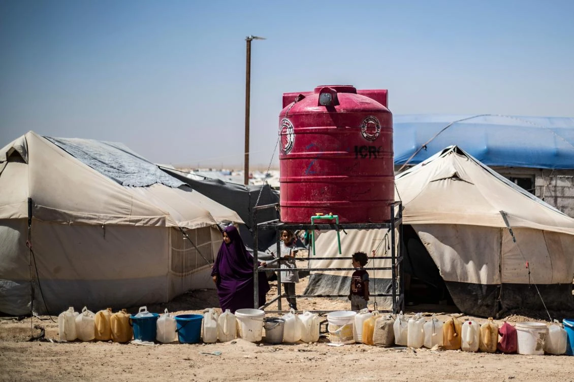 Displaced Syrians queue for water next to a tank at Al-Hol camp for the internally displaced people in Al-Hasakah governorate in northeastern Syria, on July 23, 2019. (AFP/Delil Souleiman)