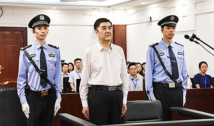 This handout photo taken on July 25, 2019 and released by the Shenyang Municipal Intermediate People's Court shows former Chinese governer of Xinjiang Nur Bekri (C) during his trial at the court in Shenyang in northeast China's Liaoning province. (AFP)