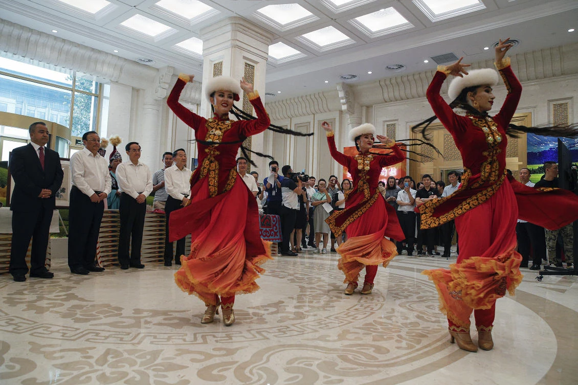 Shohrat Zakir, second from left, chairman of China’s Xinjiang Uighur Autonomous Region, and officials watch Xinjiang dancers perform a culture dance at the State Council Information Office in Beijing. (AP Photo)
