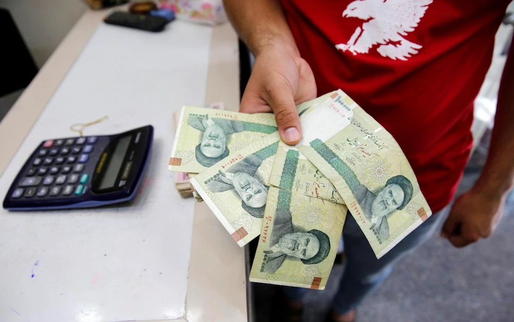 A vendor inspects Iranian rials at a currency exchange shop in Baghdad, Iraq August 8, 2018. (Reuters)