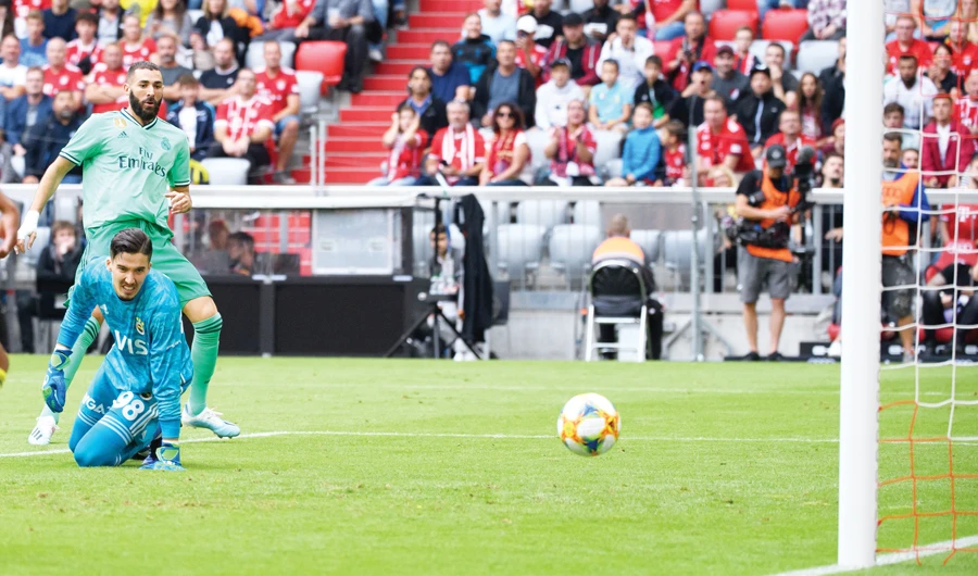 Real Madrid's French forward Karim Benzema scores past Fenerbahce's goalkeeper Altay Bayindir during their pre-season friendly on Wednesday in Munich. (AFP)