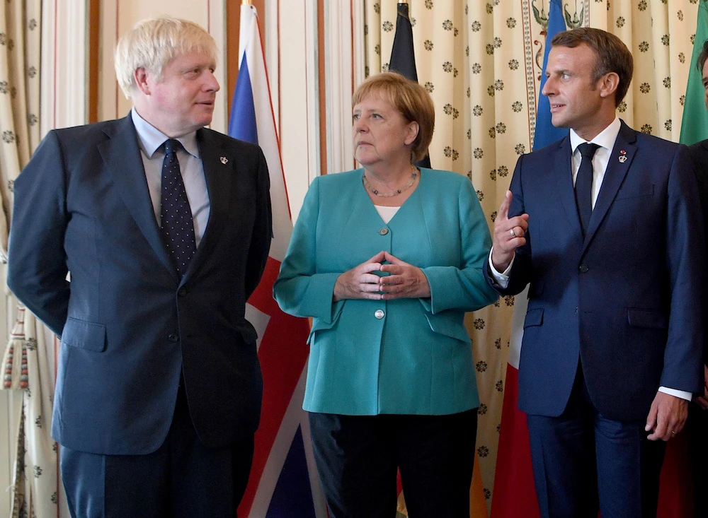 Britain’s Prime Minister Boris Johnson, French President Emmanuel Macron and German Chancellor Angela Merkel attend the G7 summit, in Biarritz, France Aug. 24, 2019. (Reuters)