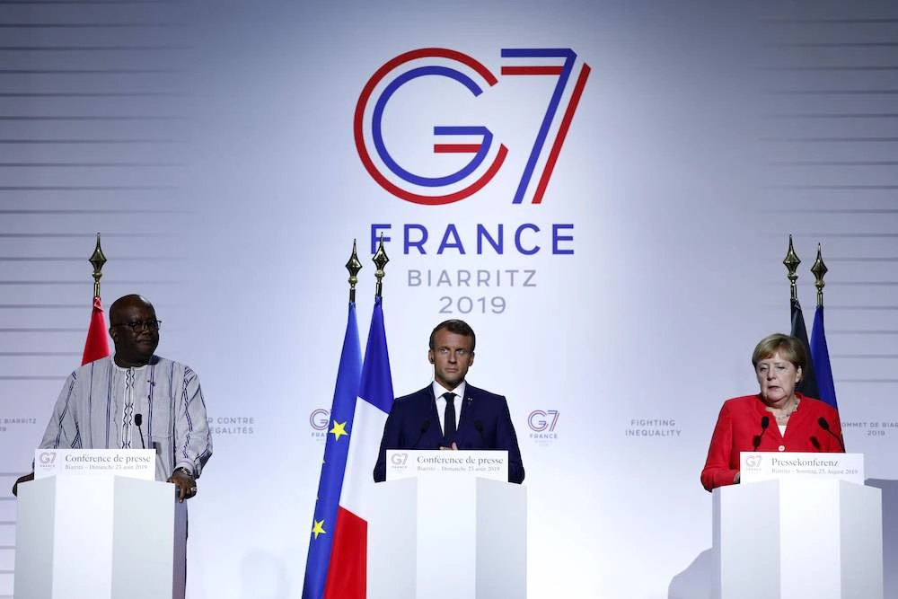 Burkina Faso President Roch Marc Christian Kabore (L), French President Emmanuel Macron (C) and German Chancellor Angela Merkel (R) speak during a press conference on the situation in Sahel during the G7 summit in Biarritz, south-west France on Aug. 25, 2019, on the second day of the annual summit. (AFP)