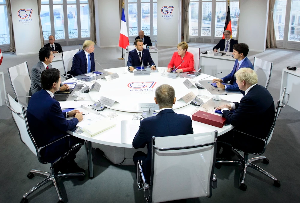 President of the European Council Donald Tusk, clockwise from center front, Italian Prime Minister Giuseppe Conte, Japan Prime Minister Shinzo Abe, U.S. President Donald Trump, President of France Emmanuel Macron, German Chancellor Angela Merkel, Canadian Prime Minister Justin Trudeau, and British Prime Minister Boris Johnson take part in a working session with G7 leaders on the second day of the G-7 summit in Biarritz, France Sunday, Aug. 25, 2019. (The Canadian Press via AP)