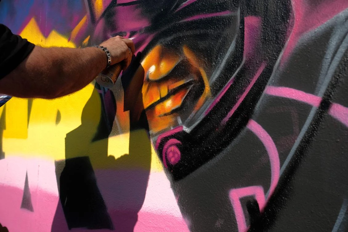 Artists spray Graffiti on a wall in the harbor in Bremerhaven, northern Germany, on August 24, 2019. Every year Graffiti artist can paint a wall on a factory building on a length of 400 meter. / AFP / PATRIK STOLLARZ