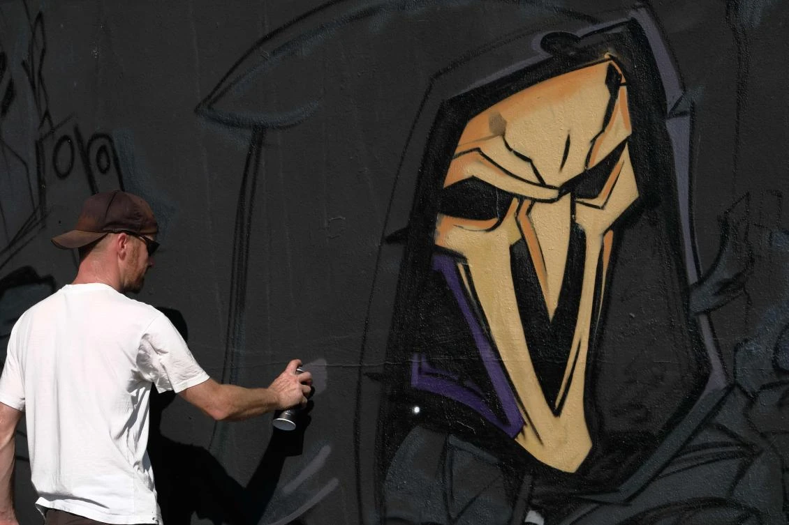 Artists spray Graffiti on a wall in the harbor in Bremerhaven, northern Germany, on August 24, 2019. Every year Graffiti artist can paint a wall on a factory building on a length of 400 meter. / AFP / PATRIK STOLLARZ