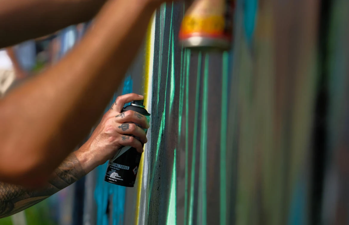 Artists spray Graffiti on a wall in the harbor in Bremerhaven, northern Germany, on August 24, 2019. Every year Graffiti artist can paint a wall on a factory building on a length of 400 meter. / AFP / PATRIK STOLLARZ